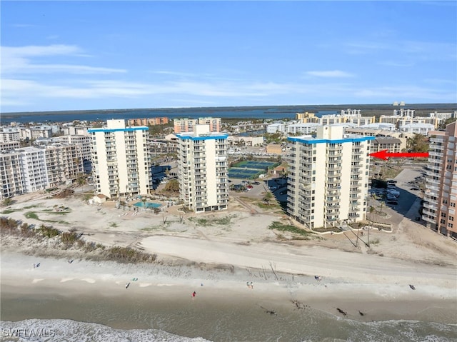 birds eye view of property with a water view and a beach view