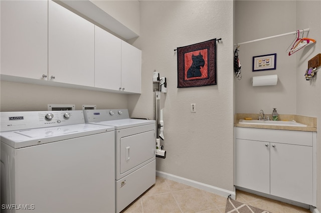 washroom featuring separate washer and dryer, sink, light tile patterned floors, and cabinets