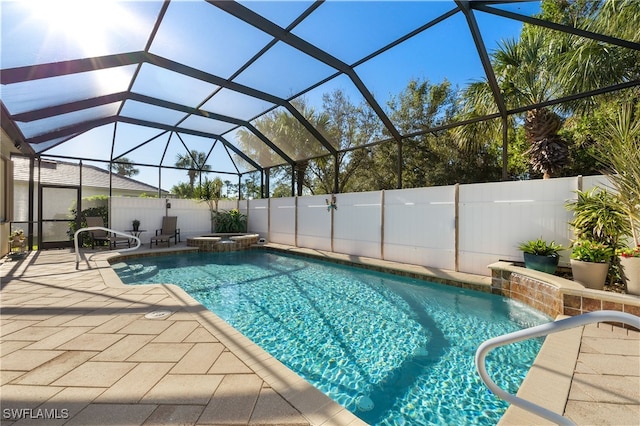 view of pool featuring glass enclosure and a patio area