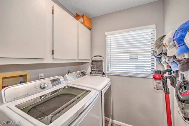 washroom with cabinets, independent washer and dryer, and a textured ceiling