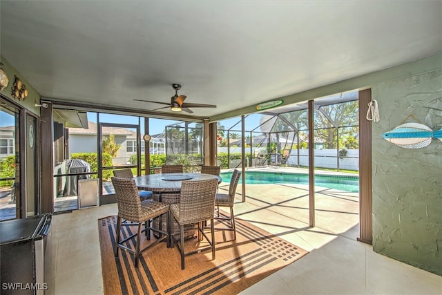 sunroom with ceiling fan, a swimming pool, and a healthy amount of sunlight