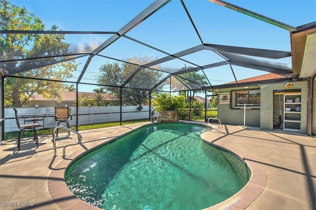 view of pool featuring glass enclosure and a patio area