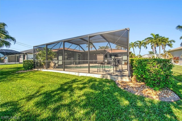 view of yard featuring glass enclosure and a patio area