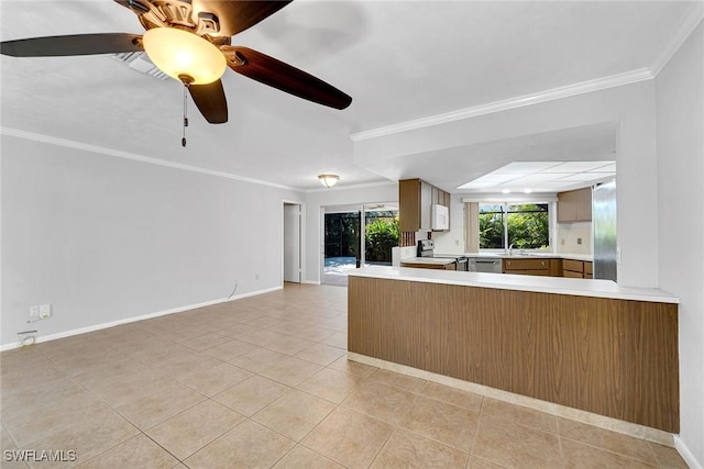 kitchen with kitchen peninsula, ornamental molding, stainless steel appliances, ceiling fan, and light tile patterned floors