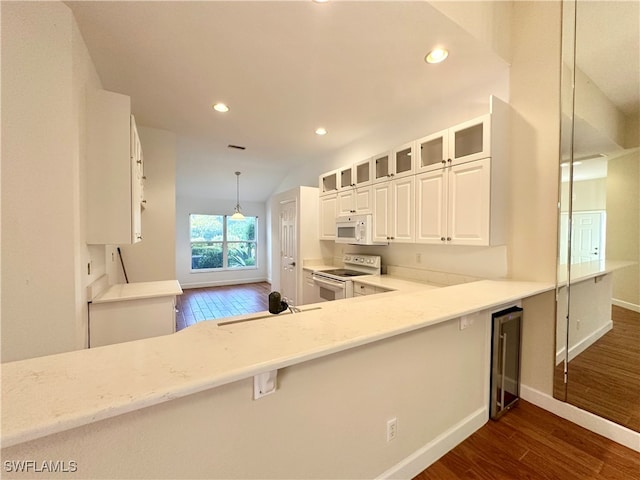 kitchen with pendant lighting, lofted ceiling, white appliances, dark wood-type flooring, and sink