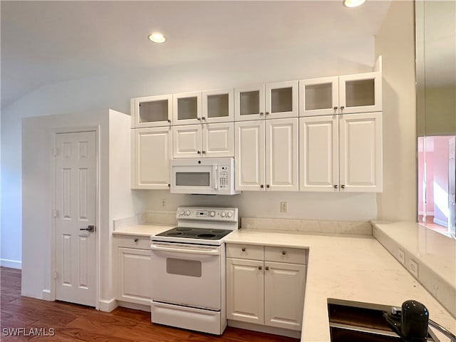 kitchen with white cabinets, white appliances, and dark hardwood / wood-style floors