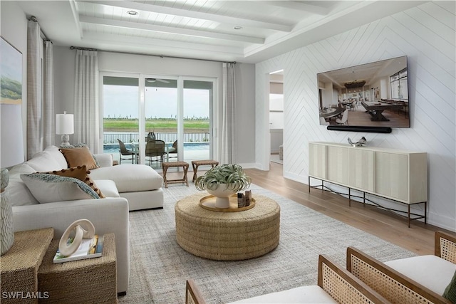 living area with beamed ceiling, baseboards, and wood finished floors