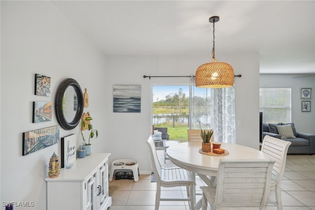 dining room with a water view and light tile patterned flooring