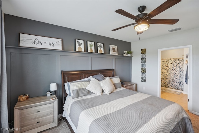 bedroom featuring ensuite bathroom, ceiling fan, and light carpet