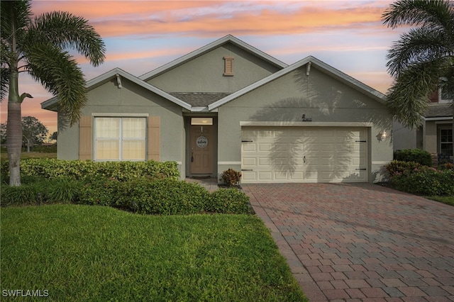 view of front facade with a yard and a garage