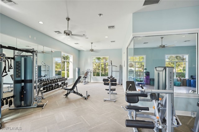 exercise room with ceiling fan and light colored carpet