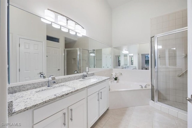 bathroom with tile patterned floors, vanity, and shower with separate bathtub