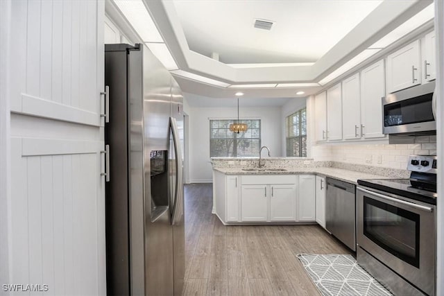 kitchen featuring pendant lighting, sink, white cabinets, and stainless steel appliances