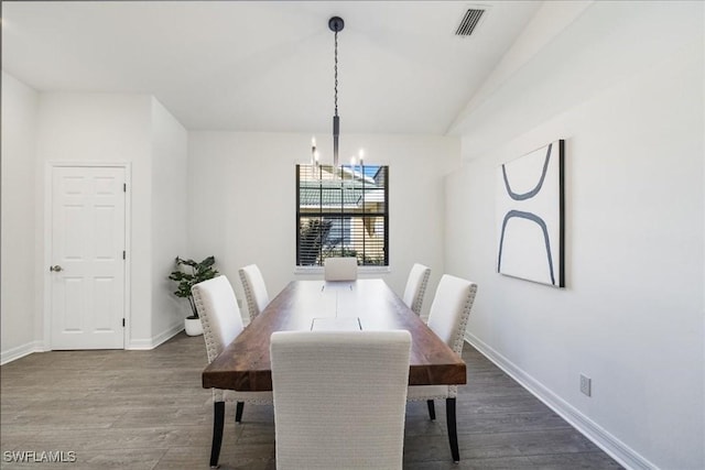 dining area featuring dark hardwood / wood-style floors and an inviting chandelier