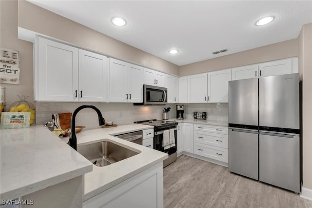 kitchen with sink, white cabinets, and appliances with stainless steel finishes