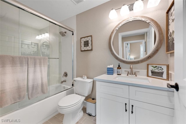 full bathroom featuring vanity, tile patterned floors, toilet, and combined bath / shower with glass door