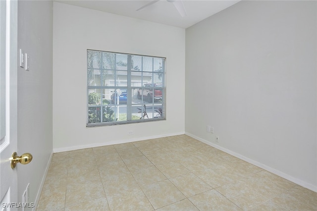 spare room with ceiling fan and light tile patterned flooring