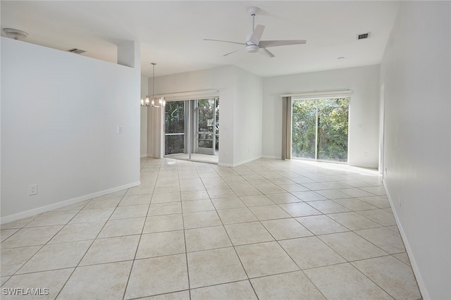 tiled empty room featuring ceiling fan with notable chandelier