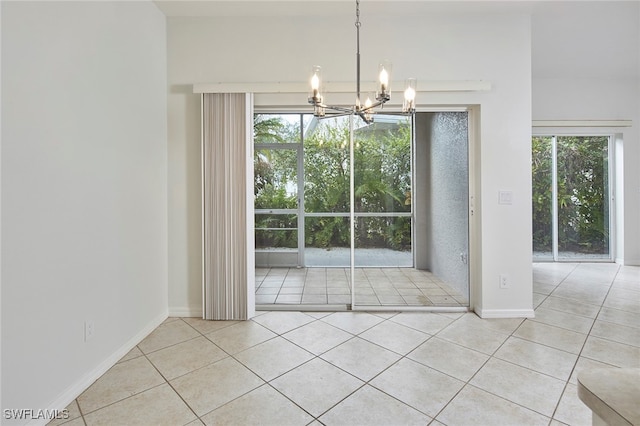 unfurnished dining area with light tile patterned floors, plenty of natural light, and a notable chandelier