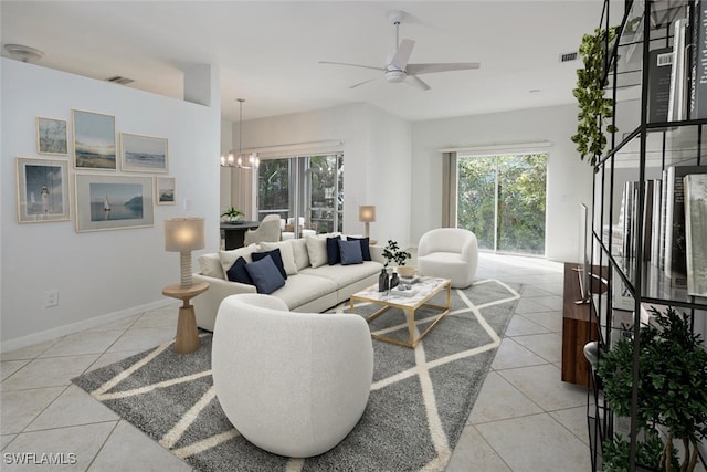 tiled living room featuring ceiling fan with notable chandelier