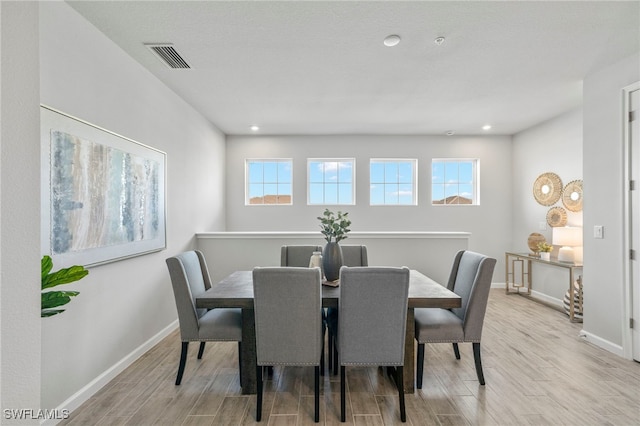 dining area with a wealth of natural light and light hardwood / wood-style flooring