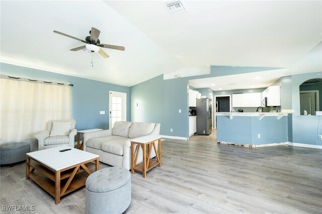 living room featuring light hardwood / wood-style flooring, ceiling fan, and lofted ceiling