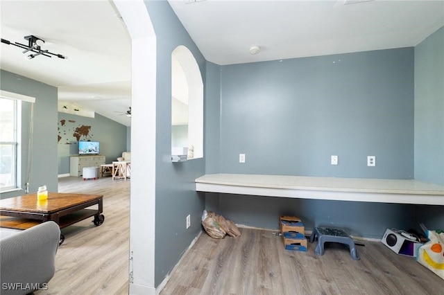 interior space featuring ceiling fan, light hardwood / wood-style flooring, and vaulted ceiling