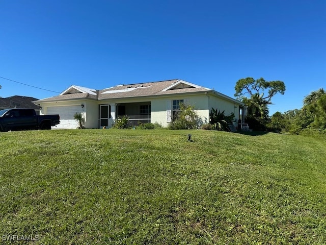 rear view of property featuring a yard and a garage