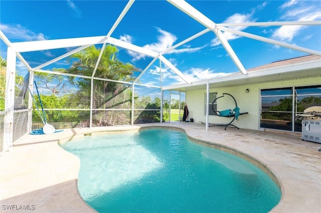 view of swimming pool with glass enclosure and a patio area