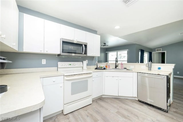 kitchen featuring kitchen peninsula, stainless steel appliances, white cabinets, and light hardwood / wood-style floors