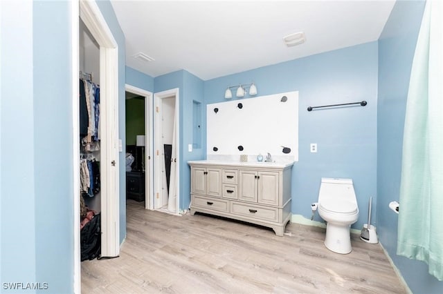 bathroom featuring vanity, hardwood / wood-style flooring, and toilet