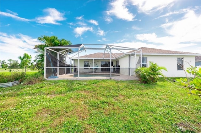 back of house with a yard, glass enclosure, a patio area, and a swimming pool