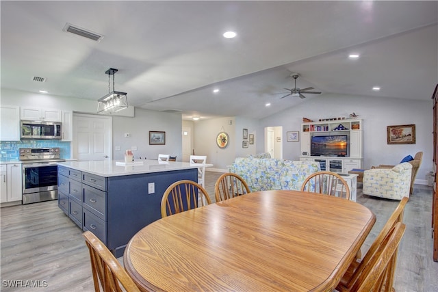 dining room featuring ceiling fan, lofted ceiling, and light hardwood / wood-style flooring