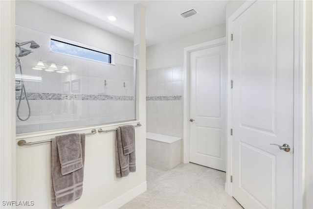 bathroom with tile patterned flooring and a tile shower