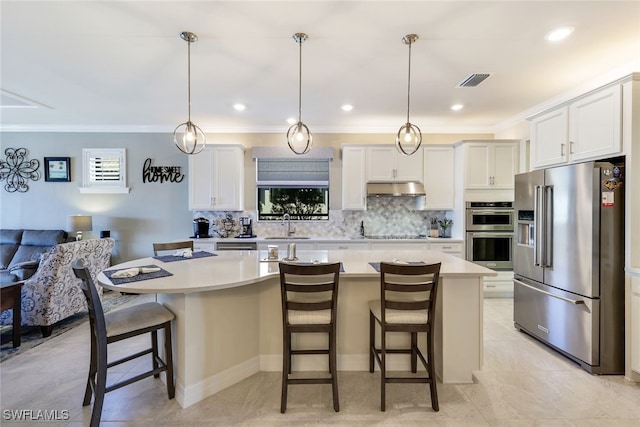 kitchen with a kitchen bar, appliances with stainless steel finishes, a center island, and white cabinetry