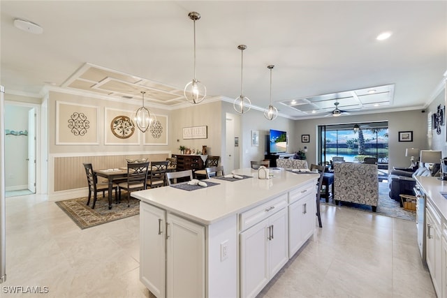 kitchen with white cabinetry, ceiling fan, hanging light fixtures, crown molding, and a kitchen island