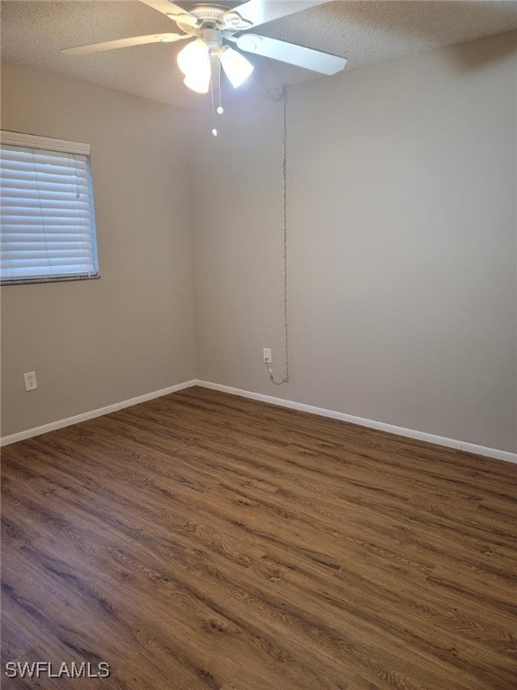 empty room featuring ceiling fan, dark hardwood / wood-style floors, and a textured ceiling