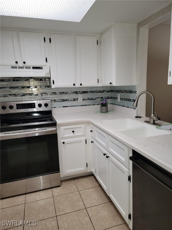 kitchen featuring sink, white cabinets, light tile patterned floors, stainless steel range with electric cooktop, and black dishwasher