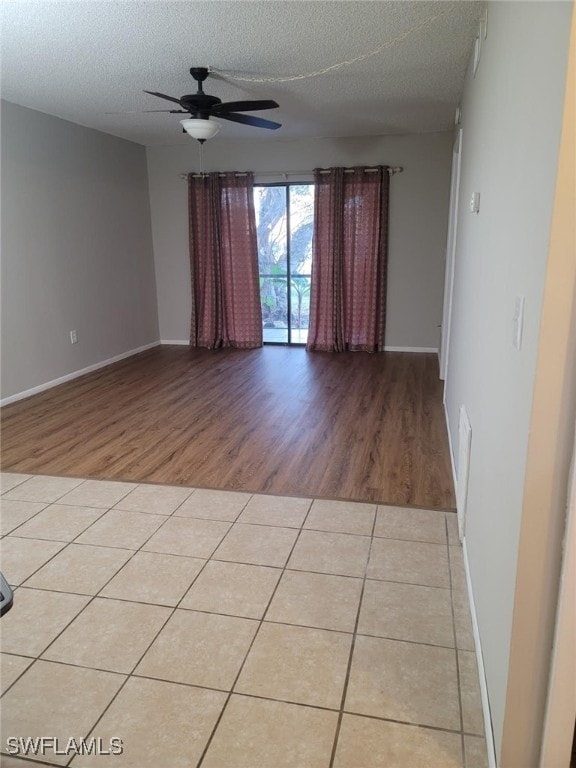 unfurnished room featuring ceiling fan, a textured ceiling, and light tile patterned floors