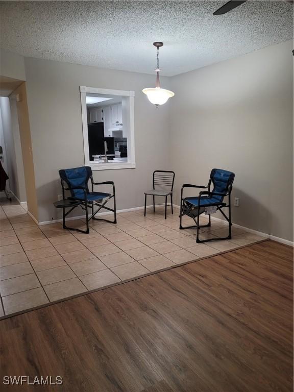 unfurnished room with light tile patterned flooring, a textured ceiling, and ceiling fan