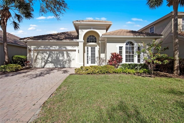 mediterranean / spanish-style home featuring a front yard and a garage