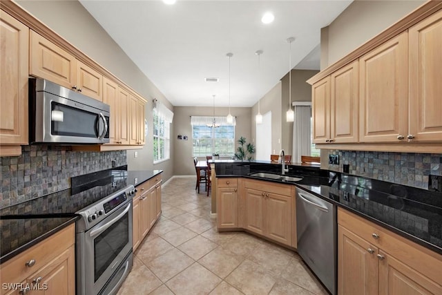 kitchen featuring decorative backsplash, appliances with stainless steel finishes, decorative light fixtures, and sink