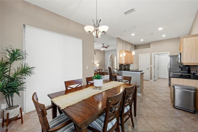 dining room with light tile patterned floors and ceiling fan with notable chandelier