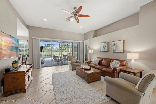 tiled living room with a wealth of natural light and ceiling fan