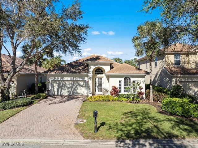 mediterranean / spanish house featuring a front lawn and a garage