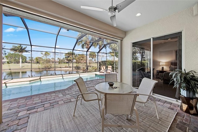 view of patio / terrace with glass enclosure, ceiling fan, and a water view