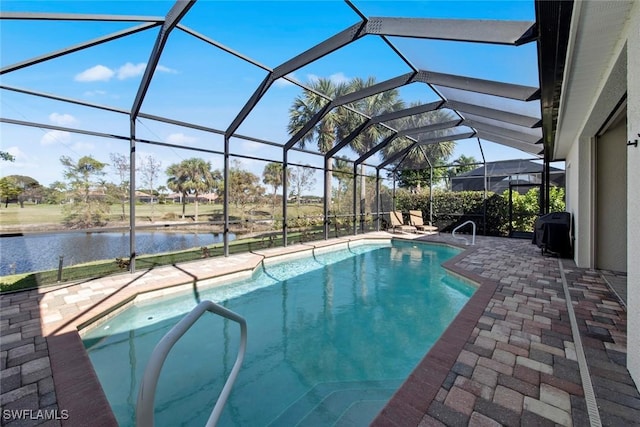 view of pool featuring glass enclosure, a water view, and a patio