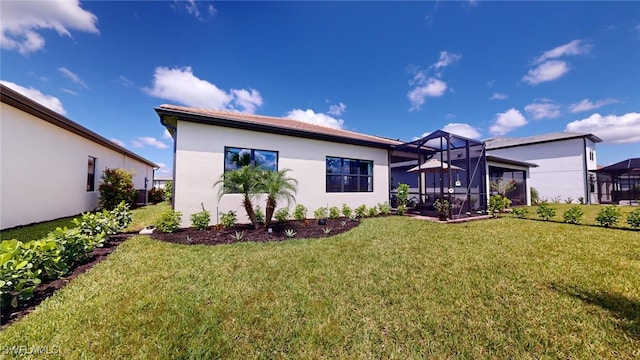 back of property with a yard and glass enclosure