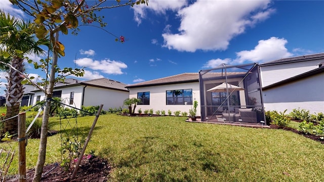 rear view of property with a lanai and a yard