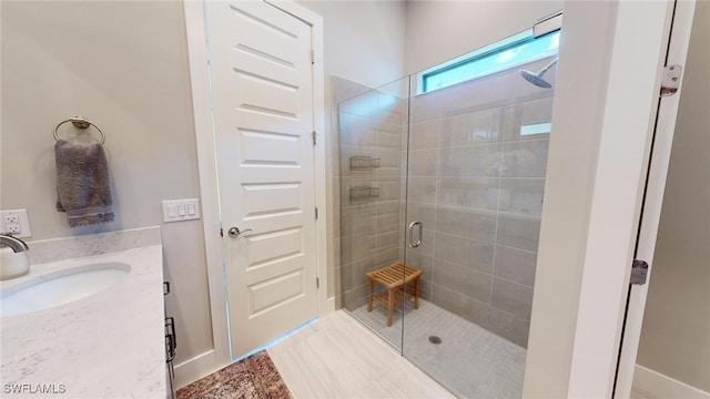 bathroom with a shower with shower door and vanity